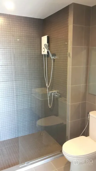 คอนโด ให้เช่าในSamut Prakan - ห้องน้ำสมัยใหม่พร้อมตู้ Shower กระจก เครื่องทำน้ำอุ่น และผนังกระเบื้องโทนเรียบ