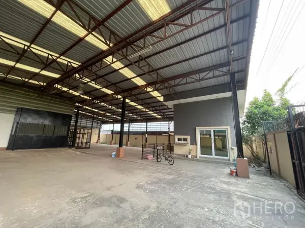 Factory for rent in Lat Lum Kaeo, Pathum Thani - Spacious factory floor with a high steel roof, skylights and an attached office.