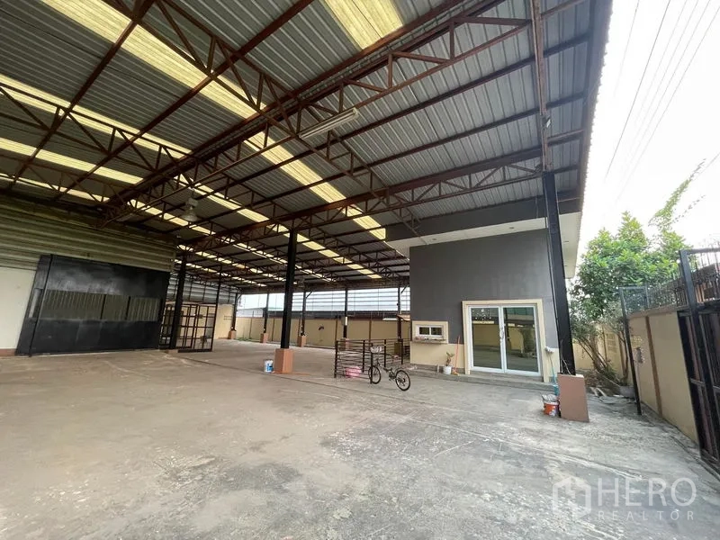 Factory for rent in Lat Lum Kaeo, Pathum Thani - Spacious factory floor with a high steel roof, skylights and an attached office.