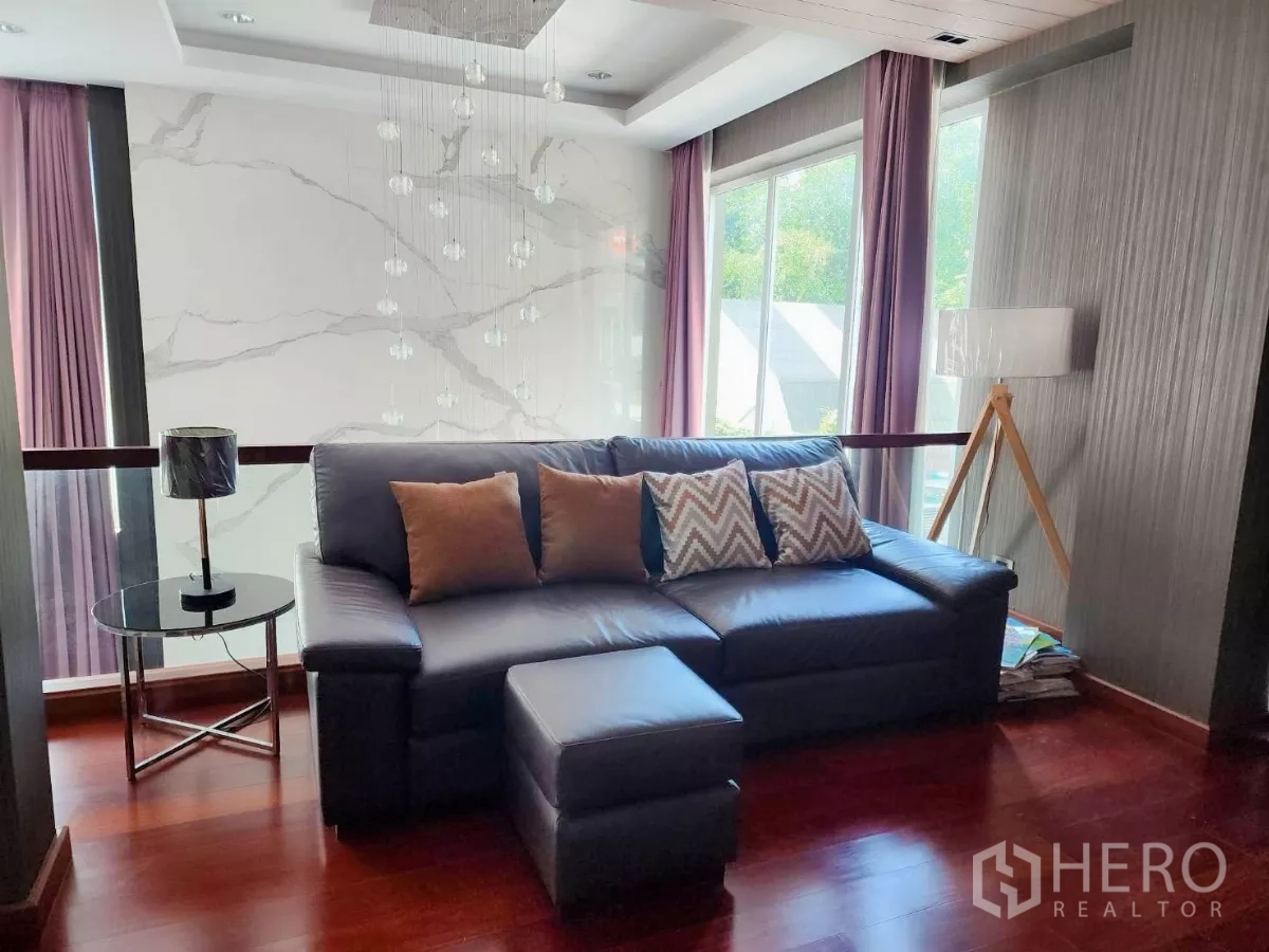 Detached House for rent or sale in Chatuchak, Bangkok - Upper-floor family lounge with leather sofa, pendant lights and large windows.
