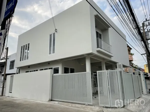 独立式住宅 出租或出售在Din Daeng, Bangkok - 两层住宅外观，转角位置，周边高围栏与大门。