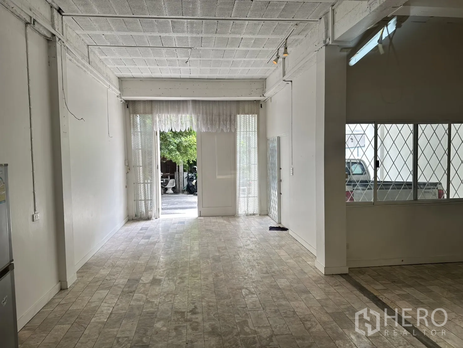 โฮมออฟฟิศ for rent in Watthana, Bangkok - ชั้นล่างสว่าง มองออกไปยังทางเข้า พร้อมประตูเหล็กดัดเลื่อน.