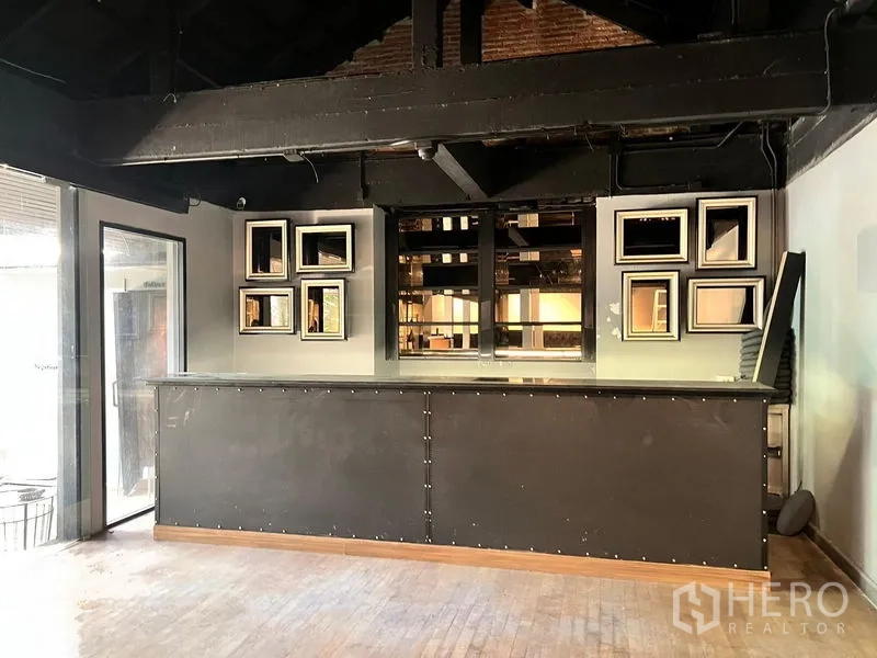 Retail Space for rent in Bangkok - Bar counter with mirrors and exposed beams in an industrial-style room.