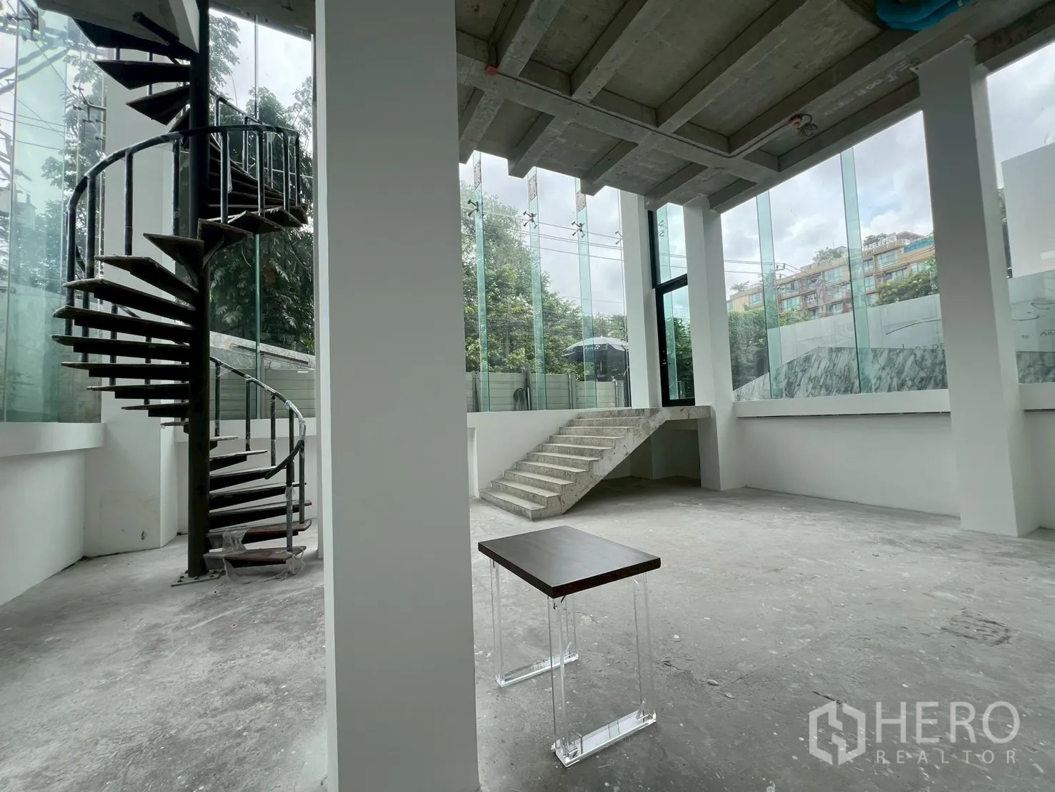 Retail Space for rent - Spacious ground floor retail hall with tall windows and a central staircase.