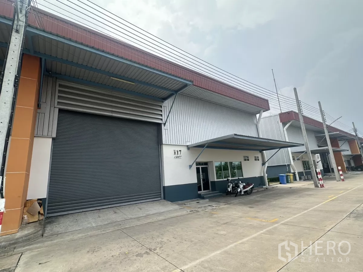 โรงงาน ให้เช่าในBang Phli, Samut Prakan - ด้านหน้าโรงงานและโกดังในบางพลี ประตูม้วนขนาดใหญ่ มีหลังคากันฝนและลานขนส่ง
