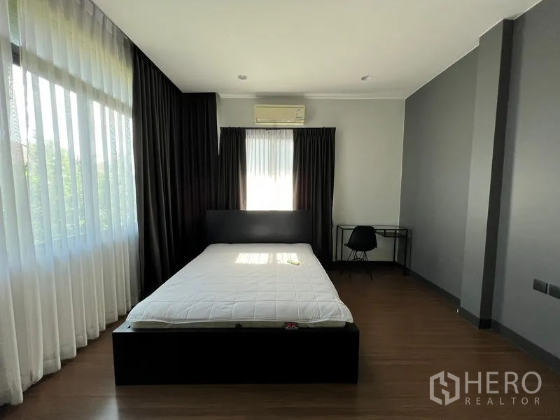 Detached House for rent or sale in Bang Kapi, Bangkok - Spacious master bedroom with large corner windows, blackout curtains and wood flooring.