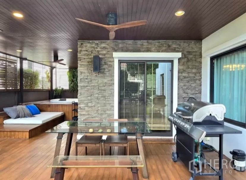 Detached House for rent in Bang Phli, Samut Prakan - Covered terrace with stone wall, ceiling fan, glass-top table and BBQ grill