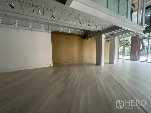 Retail Space for rent in Khlong Toei, Bangkok - Spacious corner of the retail floor with support columns and full-height street-facing windows.