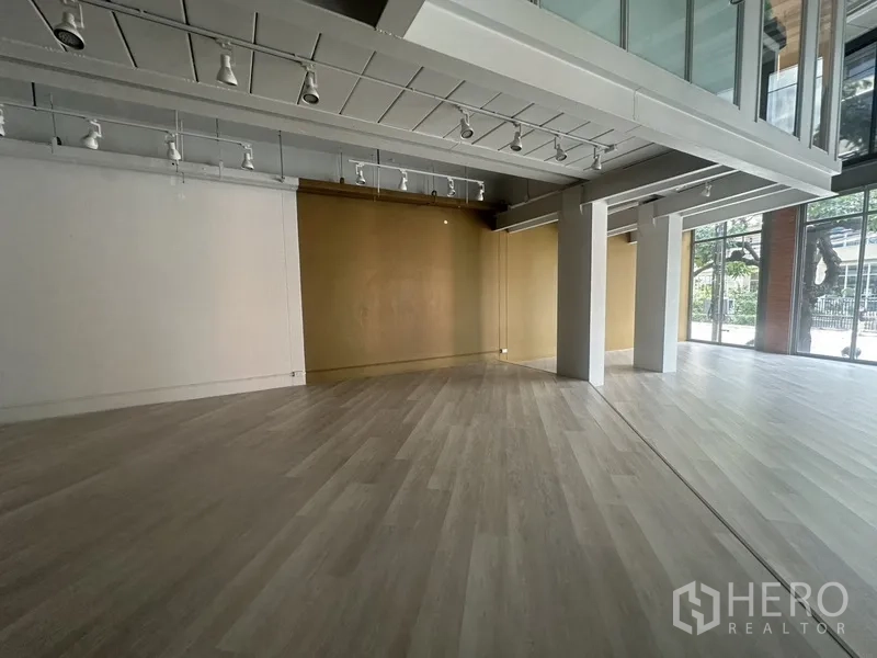 Retail Space for rent in Khlong Toei, Bangkok - Spacious corner of the retail floor with support columns and full-height street-facing windows.
