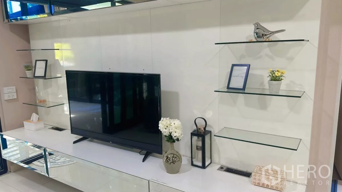 Detached House for rent or sale in Bang Kapi, Bangkok - Close-up of TV console with glass shelves and decorative accents.