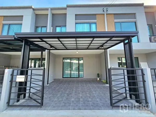 Townhouse for rent in Bang Phli, Samut Prakan - Modern two‑storey townhouse facade with a covered double carport and sliding gate.