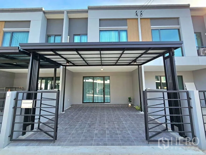Townhouse for rent in Bang Phli, Samut Prakan - Modern two‑storey townhouse facade with a covered double carport and sliding gate.