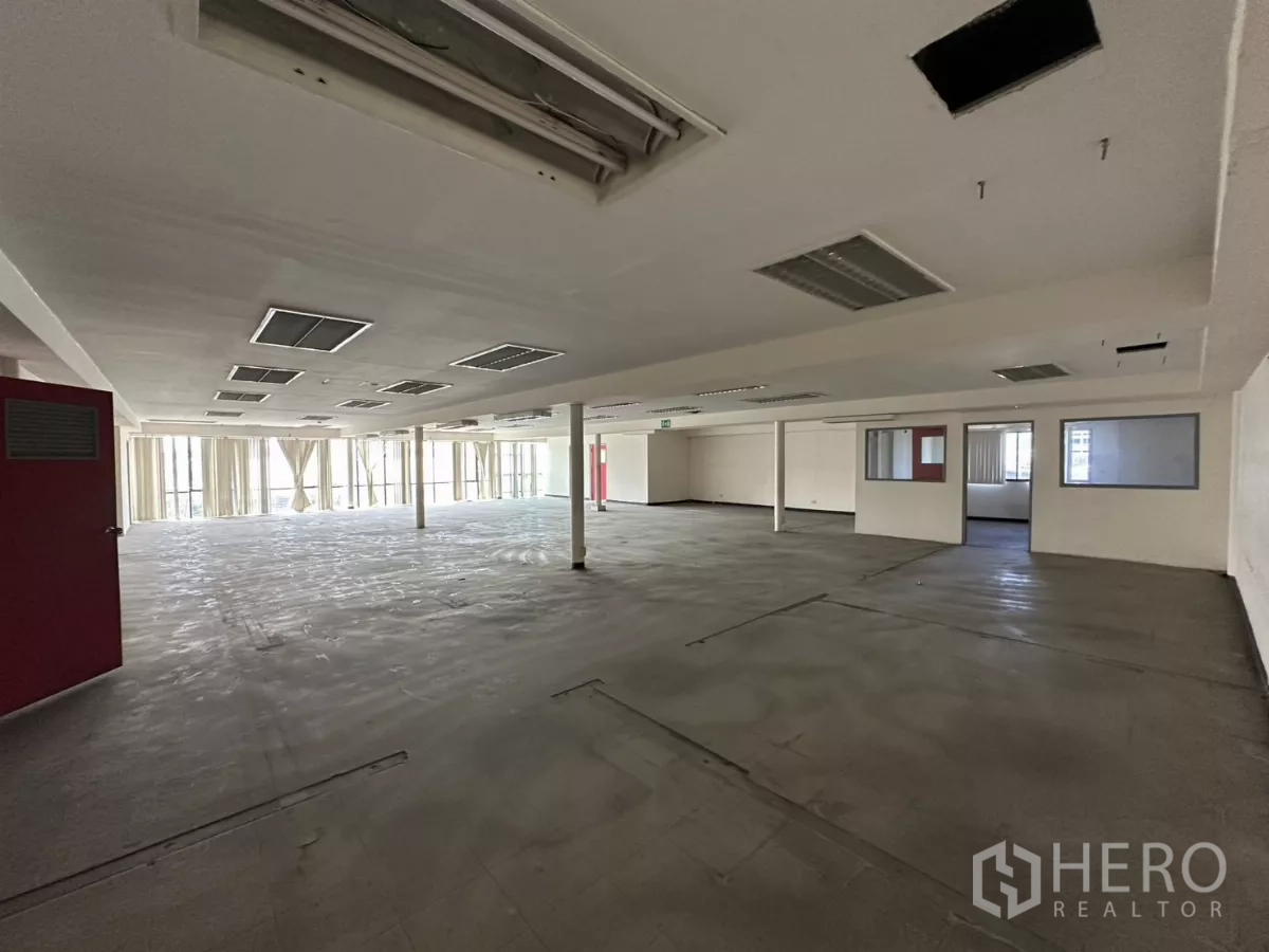 Warehouse for rent in Suan Luang, Bangkok - Open office floor with numerous ceiling light fixtures and support columns.