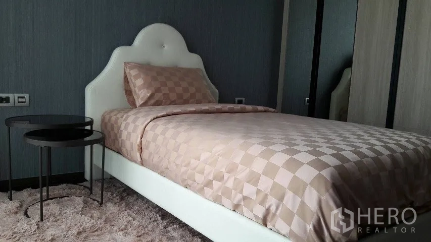 公寓 出租或出售在Watthana, Bangkok - 次卧为单人床，棋盘格床品，毛绒地毯与衣柜配置齐全。