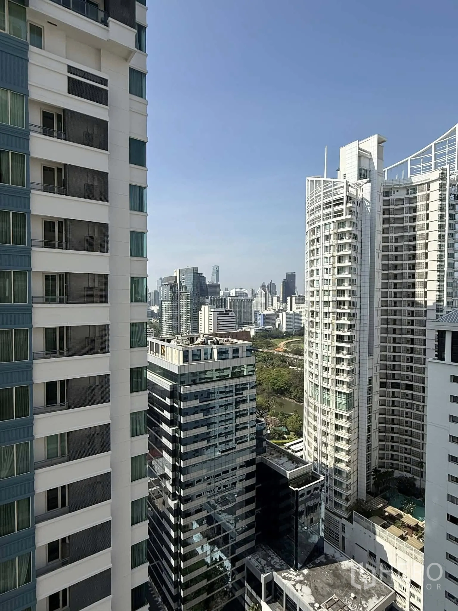 Condominium for rent in Pathum Wan, Bangkok - High-floor city skyline view framed by modern high-rise buildings.