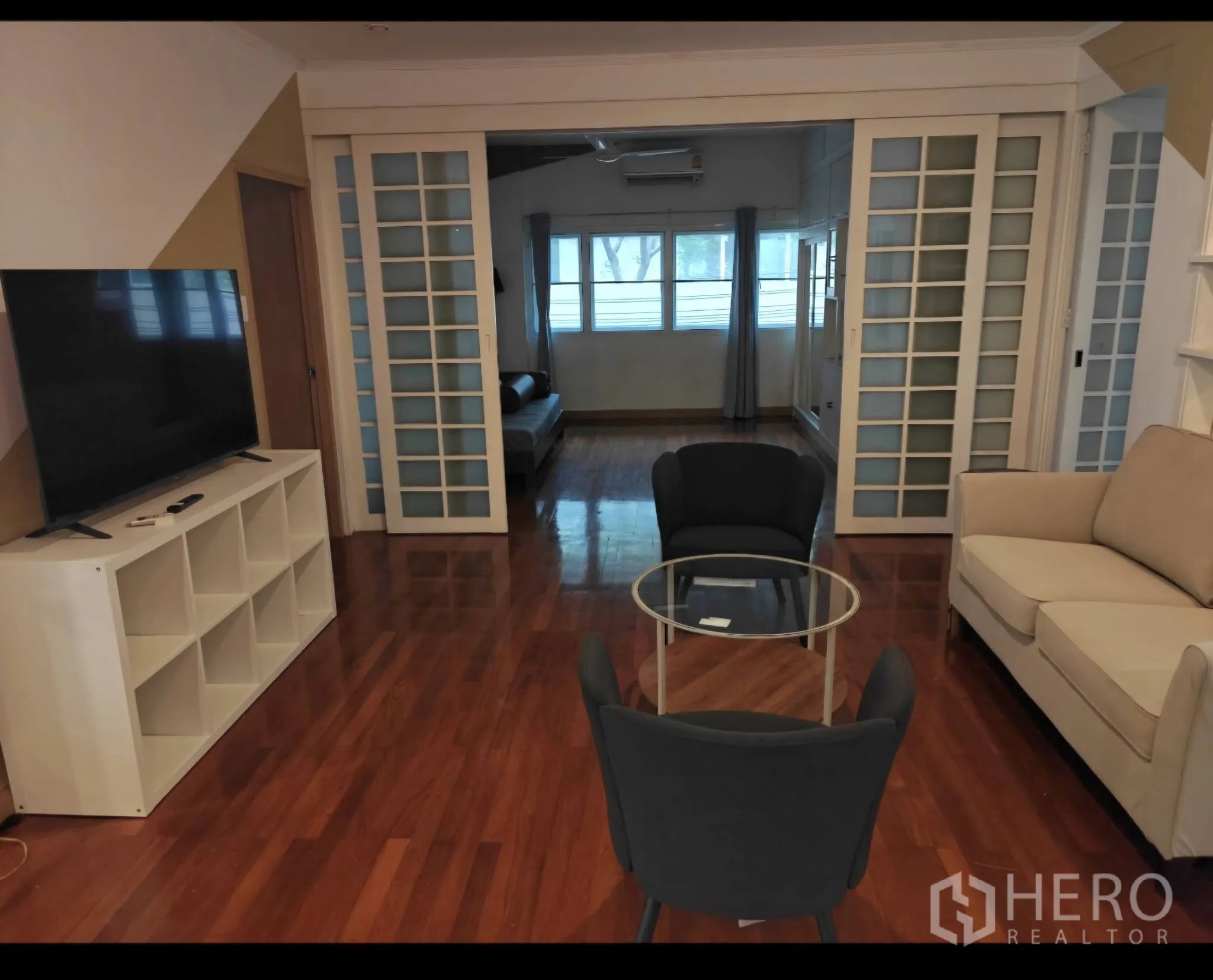 公寓 for rent in Sathon, Bangkok - 电视休闲区设沙发、玻璃茶几，玻璃推拉门通向多功能房。