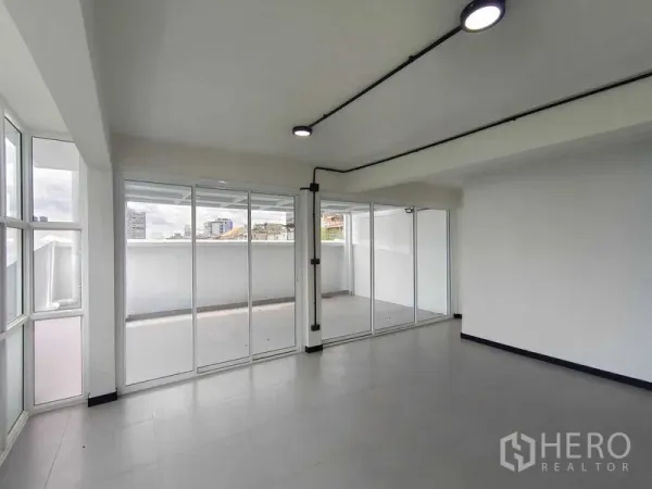联排别墅 出售在Bang Phlat, Bangkok - 采光充足的起居区，落地推拉门通向大阳台，远眺城市景观。