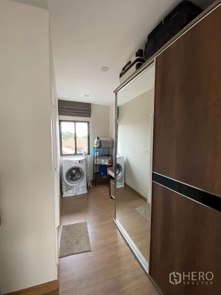 Townhouse for rent in Suan Luang, Bangkok - Utility room with mirrored wardrobe, washing machine and window for natural light.
