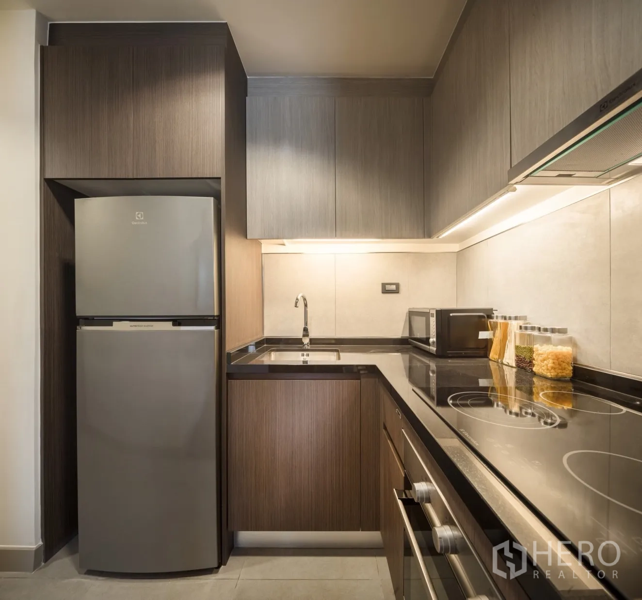 Condominium for rent in Khlong Toei, Bangkok - Close-up of modern kitchen featuring electric stove, oven and countertop appliances.