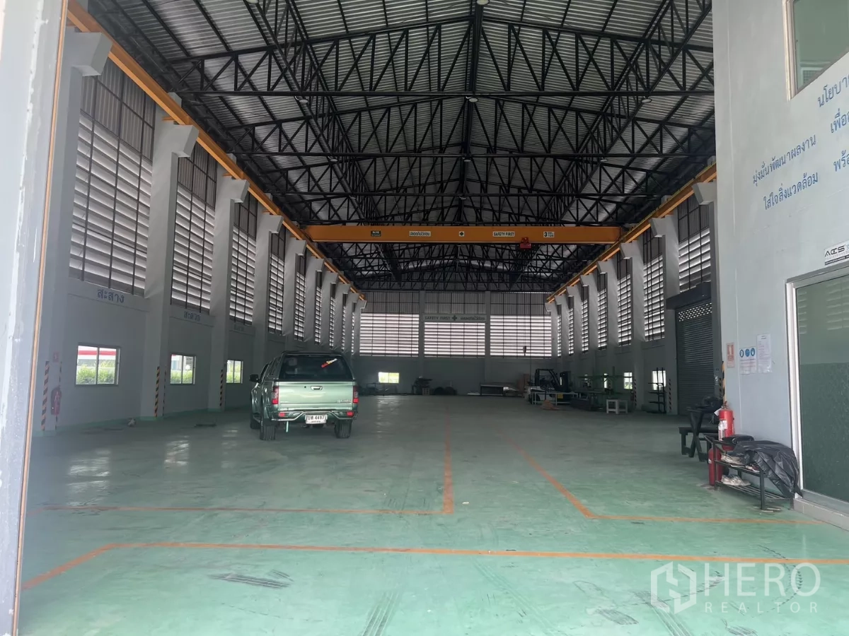 Factory for sale in Lat Lum Kaeo, Pathum Thani - Factory interior with bridge crane, high clearance, and marked loading zones on the floor.