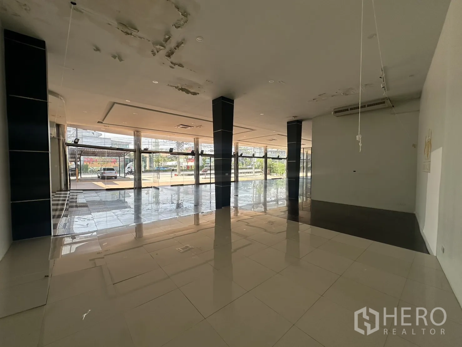 Showroom for rent in Suan Luang, Bangkok - Rear showroom section with raised platform and areas of ceiling repair.