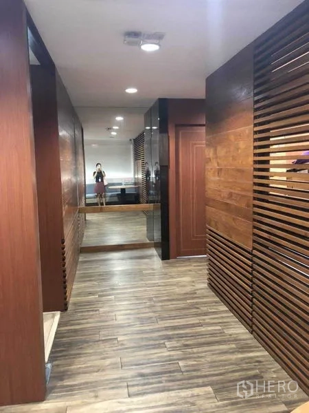 Office Space for sale in Watthana, Bangkok - Wood-paneled corridor with mirrors and recessed lighting in a Bangkok office.