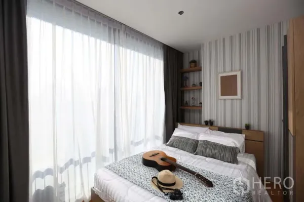 公寓 出售在Bang Rak, Bangkok - 卧室配落地纱帘与大窗，自然光洒在双人床上。