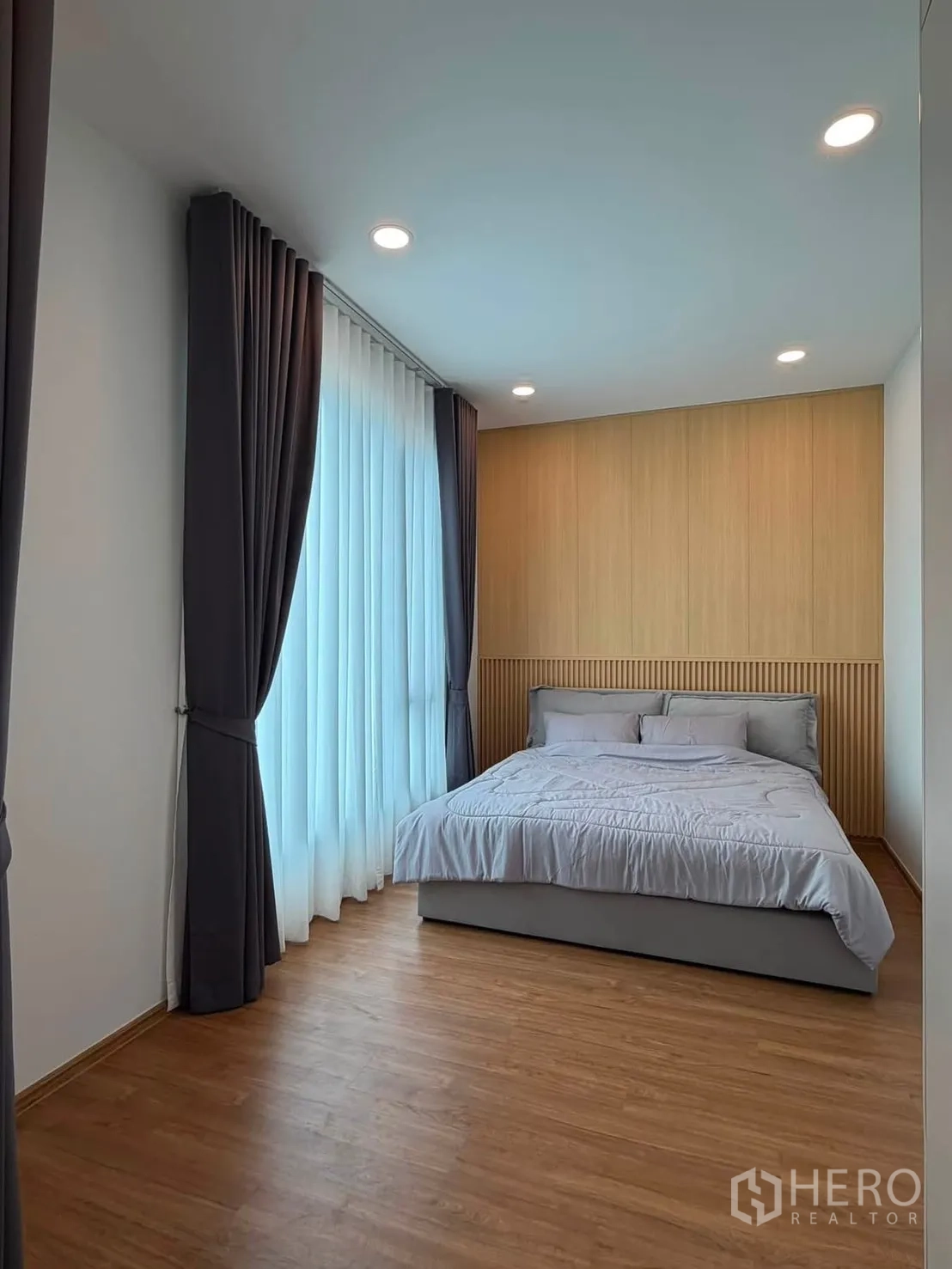ทาวน์เฮาส์ for rent in Bang Phli, Samut Prakan - ห้องนอนมาสเตอร์ หน้าต่างสูงจรดเพดาน ผ้าม่านทึบ และพื้นลายไม้