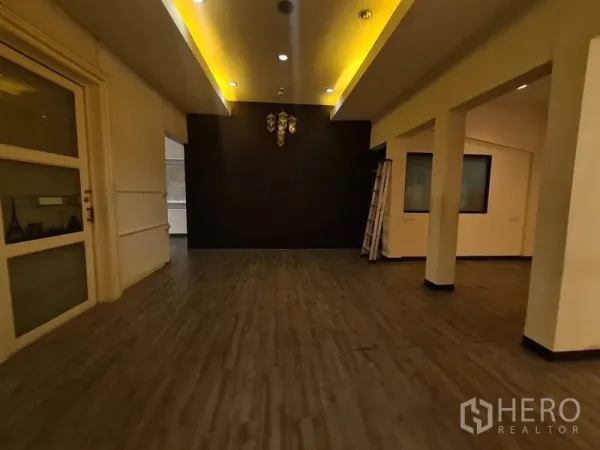 Retail Space for rent in Watthana, Bangkok - Gallery-style space with cove ceiling lighting and a chandelier on a dark feature wall.