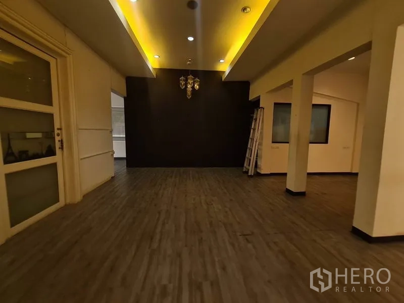Retail Space for rent in Watthana, Bangkok - Gallery-style space with cove ceiling lighting and a chandelier on a dark feature wall.