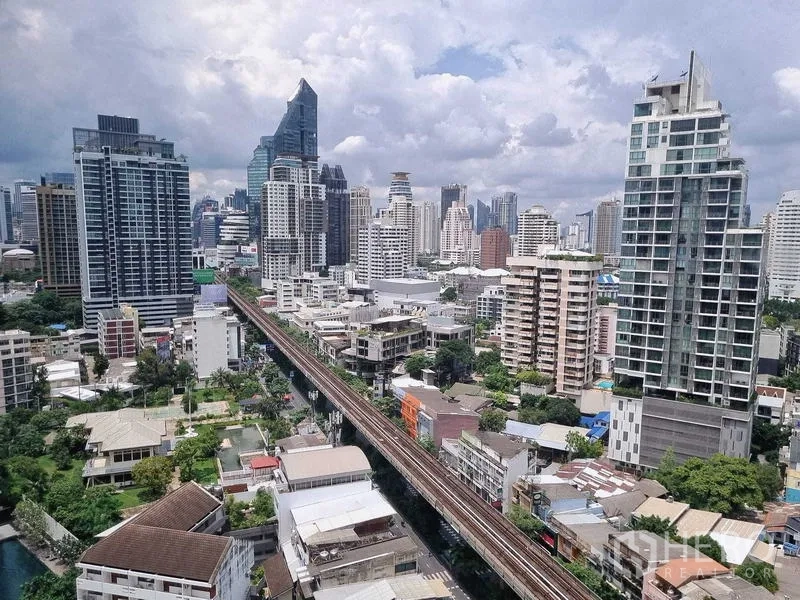 Condominium for sale - High-floor Bangkok skyline with BTS rail line running through the district.