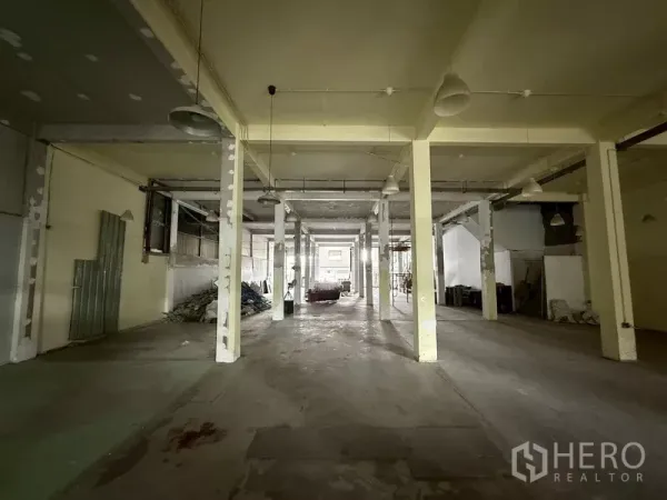 Shophouse for rent - Deep warehouse-style hall with rows of pillars and industrial lighting.