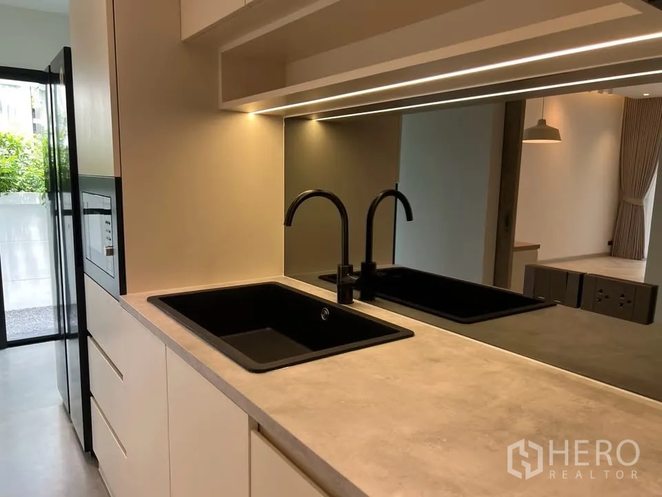 联排别墅 for rent in Prawet, Bangkok - 厨房双黑色水槽与灯带背板特写。