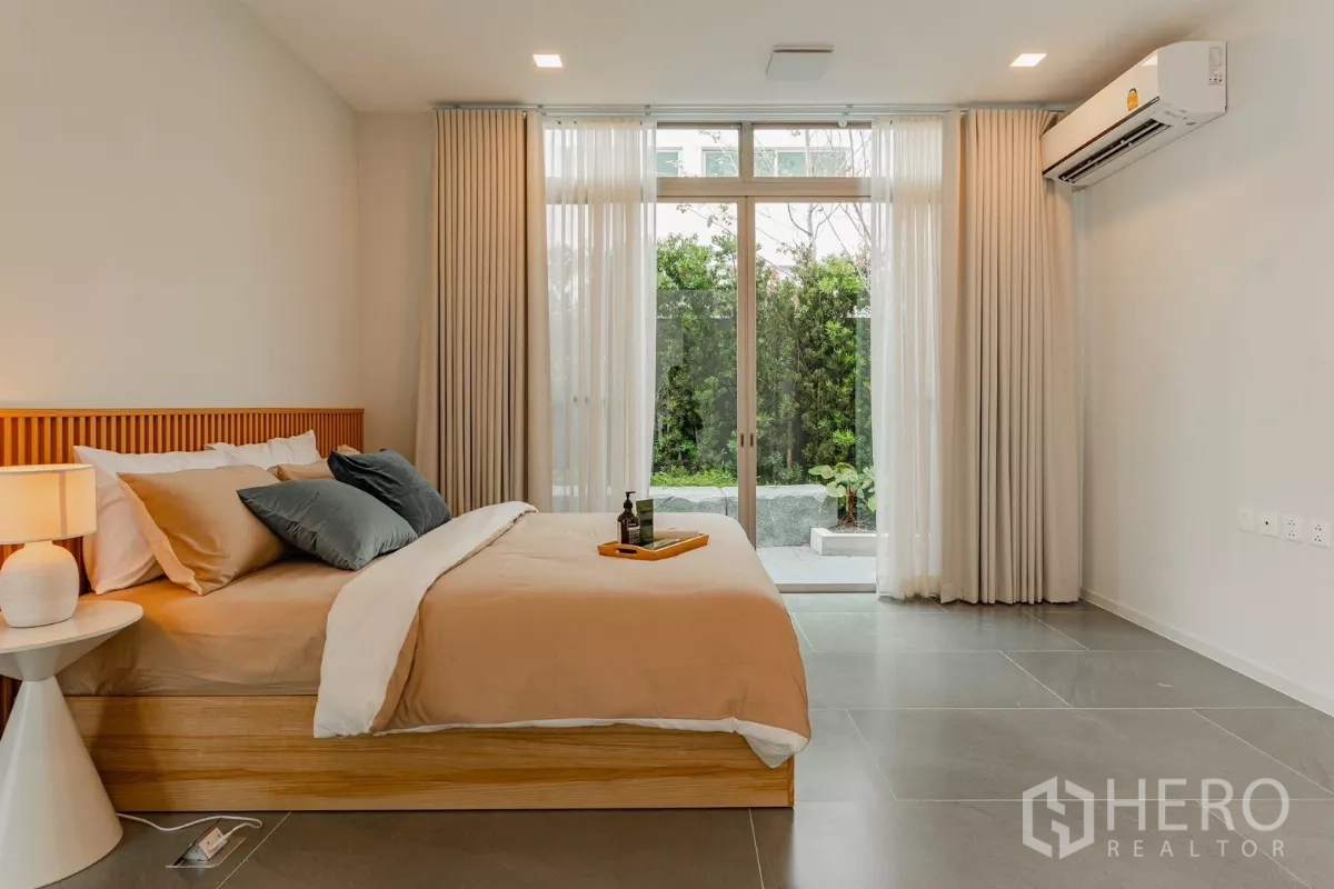 Detached House for rent in Saphan Sung, Bangkok - Ground-floor bedroom with glass doors opening to a private garden.