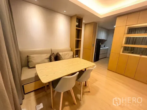Condominium for rent or sale - Warm wood-toned dining nook with built-in bench, three chairs, and open shelving beside a compact kitchen.