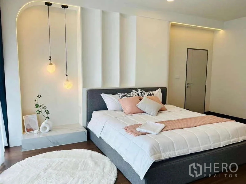 Detached House for rent in Bang Phli, Samut Prakan - Spacious bedroom with pendant lights, accent wall and neatly dressed queen bed.
