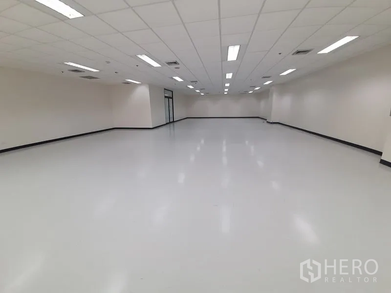 Office Space for rent in Bang Rak, Bangkok - Long rectangular office featuring central air vents and a double glass door at the far end.