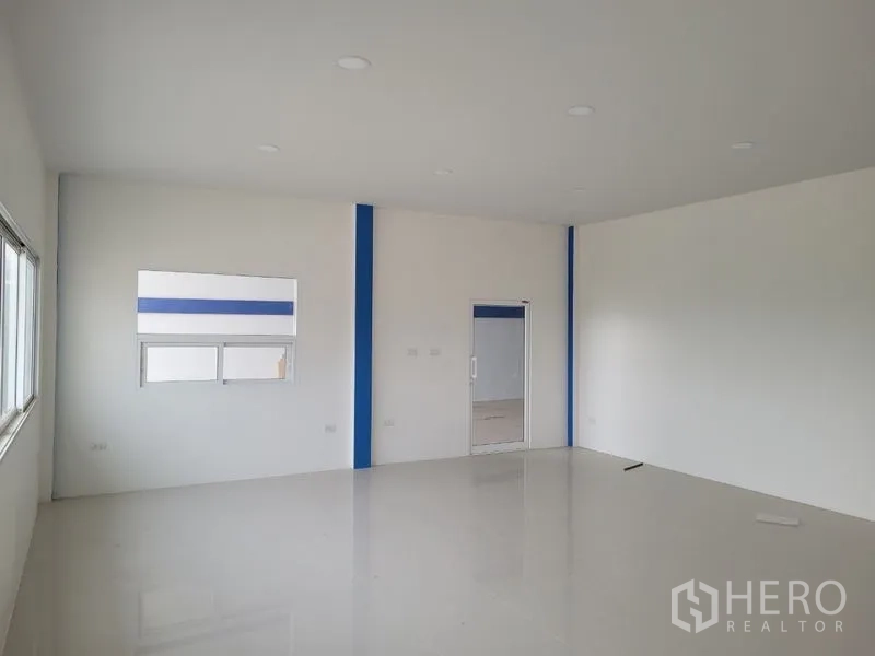 Factory for rent or sale in Khlong Luang, Pathum Thani - Bright office level with white walls, tiled flooring, and recessed lighting.