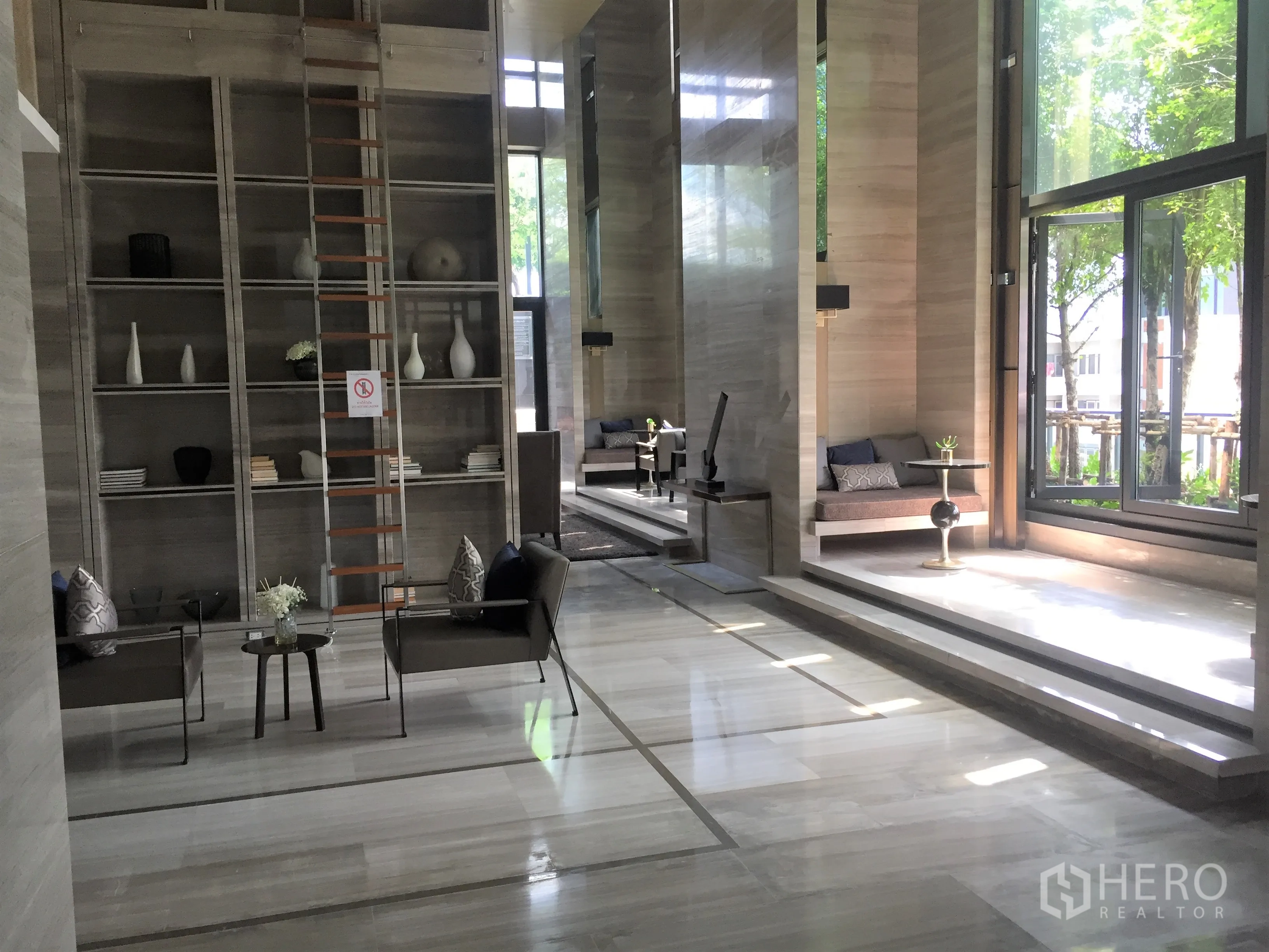 公寓 出租或出售在Ratchathewi, Bangkok - 公共大堂挑高设计，书架与休闲座位区。