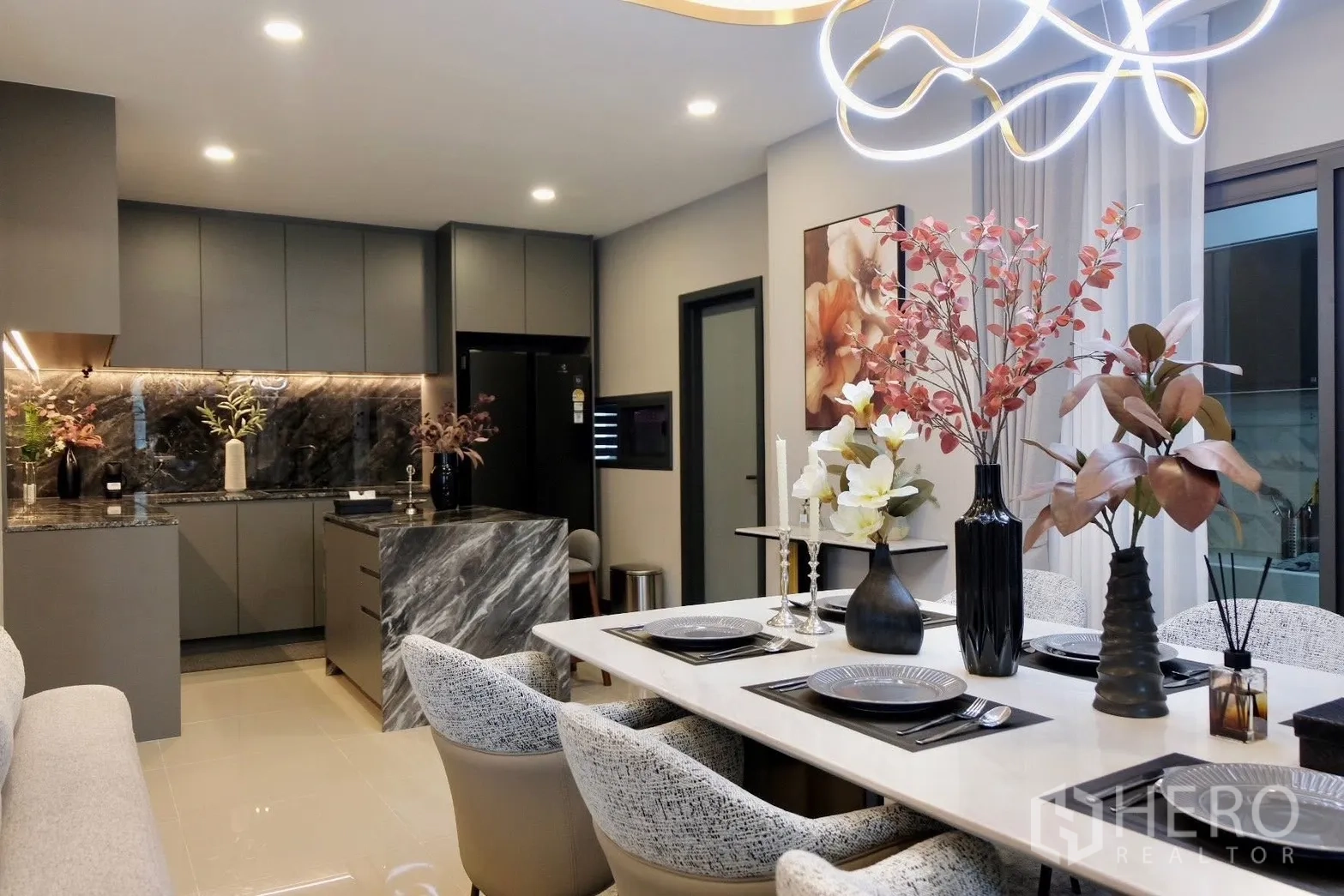 半独立式住宅 for sale in Prawet, Bangkok - 餐区摆放六人餐桌，邻近设计感厨房与吊灯。