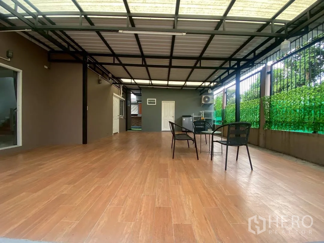 独栋房屋 for rent in Suan Luang, Bangkok - 带顶露台，木纹地面与户外桌椅。