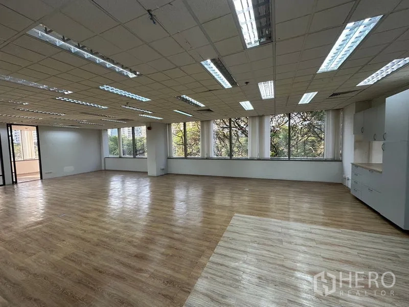 สำนักงาน ให้เช่า - พื้นที่ทำงานกว้าง มีหน้าต่างยาวรับแสงธรรมชาติ พื้นไม้ลามิเนต และตู้แพนทรีบิลท์อิน.