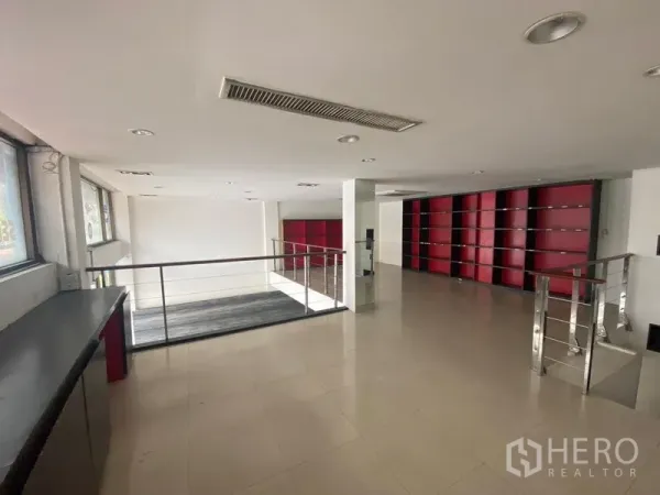 Retail Space for rent in Watthana, Bangkok - Mezzanine retail floor with tiled flooring, ceiling spotlights, and built-in red shelving.