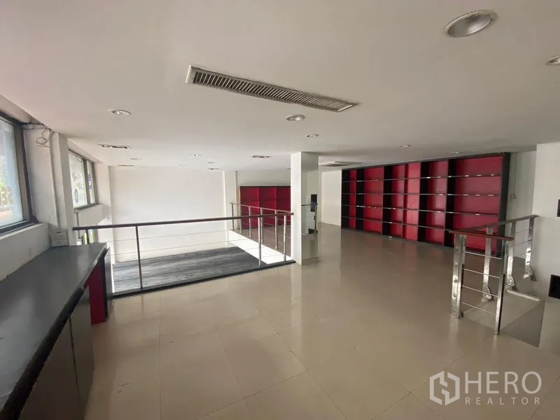 Retail Space for rent in Watthana, Bangkok - Mezzanine retail floor with tiled flooring, ceiling spotlights, and built-in red shelving.