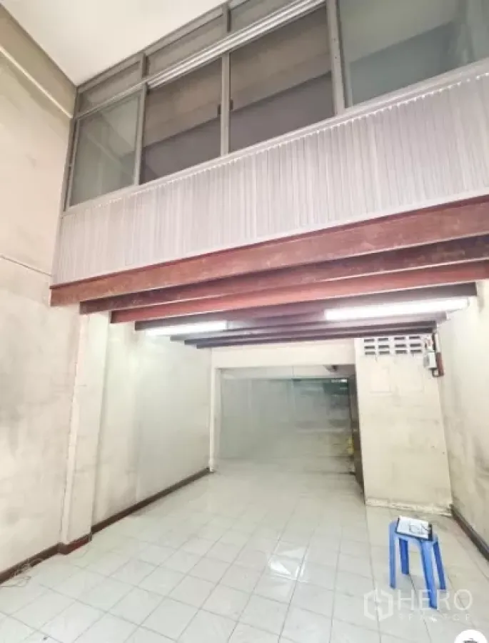 店屋 出租在Watthana, Bangkok - 一层店面大厅，白色地砖、外露木梁与上方玻璃窗。