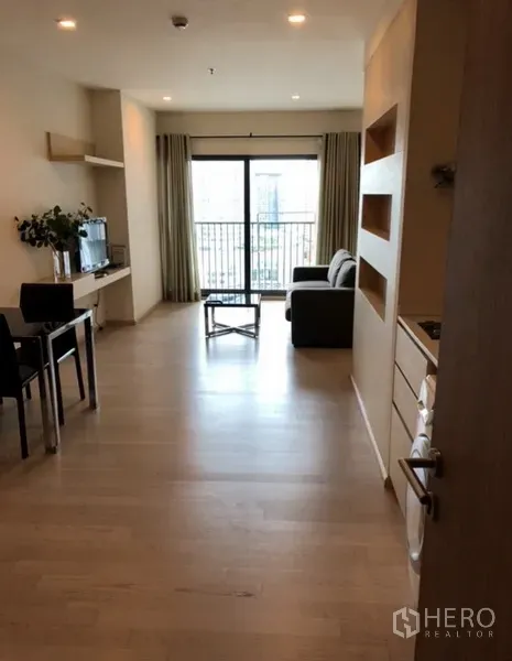 公寓 出租在Khlong Toei, Bangkok - 从玄关望向客厅，设餐桌、电视柜与通往阳台的落地门