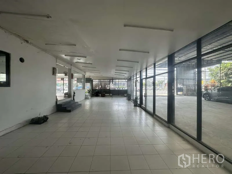 คลังสินค้า ให้เช่าในPak Kret, Nonthaburi - พื้นที่โชว์รูมด้านหน้า ปูพื้นกระเบื้อง ไฟเพดาน และผนังกระจกมองเห็นถนน