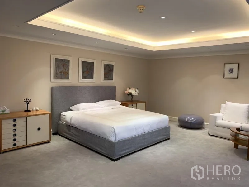 公寓 出租或出售在Watthana, Bangkok - 主卧配软包床、嵌灯与舒适休闲角。