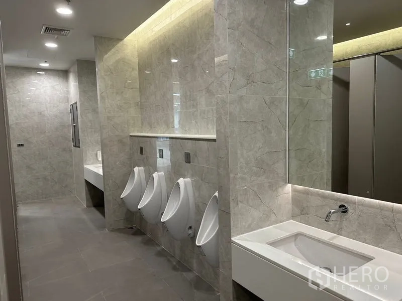 สำนักงาน ให้เช่าในRatchathewi, Bangkok - ห้องน้ำชายสมัยใหม่ ผนังลายหิน พร้อมโถปัสสาวะและอ่างล้างมือ