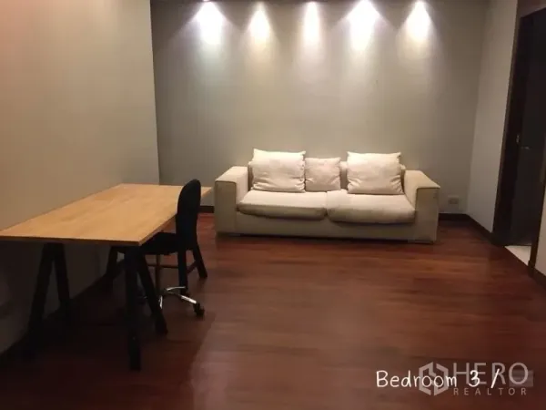 คอนโด ให้เช่าในSathon, Bangkok - ห้องอเนกประสงค์มีโต๊ะไม้และโซฟาสีครีม ผนังติดไฟสปอตไลท์